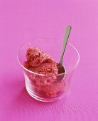 Raspberry ice cream in glass with spoon