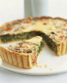 Spinach tart with cherry tomatoes, partly slices