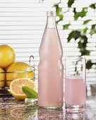 Pink grapefruit lemonade in glass and bottle