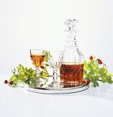 Rose hip liqueur in carafe and glasses on tray