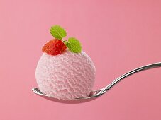 A scoop of strawberry ice cream on a spoon