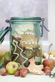 Spekulatius (German Christmas shortcrust biscuits) in a preserving jar surrounded by apples and nuts