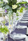 Table laid for special occasion with glass tableware and flowers