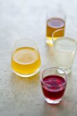 Different fruit liqueurs in four glasses