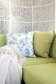 Pale green sofa with cushions and throw