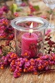 Candle in glass with wreath of spindle tree fruit