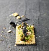 Black caviar, avocado and tuna on cracker