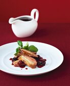 Duck breast with cherry sauce, sauce-boat in background