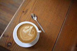 Coffee with milk foam on wooden table