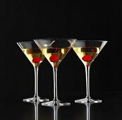 Drei Martinis mit Cocktailkirschen