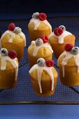 Iced buns with berries on cake rack