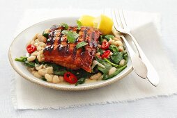 Glazed grilled salmon fillet with spinach and white beans