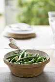 Green beans with almonds in ceramic bowl on table