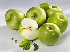 Several green apples (whole and halved)