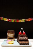 Still life with chocolate cake, biscuits and Gummi bears