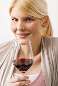 Blond woman holding glass of red wine