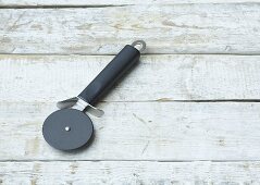 Pizza cutter on wooden background