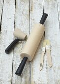 Rolling pin, small pastry roller and pastry brushes on wooden background