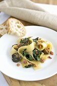 Fettuccine with ceps, bacon and spinach on plate