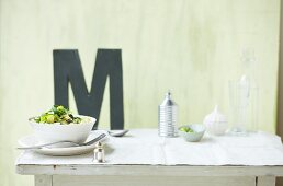 Pasta with courgettes and lime, letter M in background