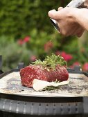 Seasoning beef fillet on barbecue with pepper