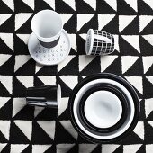 Black and white cups and bowls on checked tablecloth