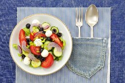 Tomato, cucumber and onion salad with mozzarella and olives