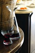 A glass of red wine and a carafe in a restaurant