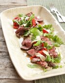 Peppered beef fillet with red peppers and salad leaves