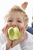 A little boy eating an apple
