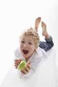 A little boy holding a half-eaten apple
