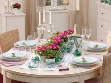 Table decoration for New Year's Eve: primulas, 4-leaf clover, lucky pigs