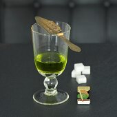 Glass of absinthe with spoon, matches and sugar cubes