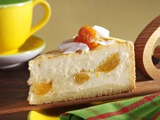 Piece of cheesecake with apricots and coconut shavings