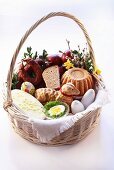 Osterkorb mit Kuchen, Wurst und Brot