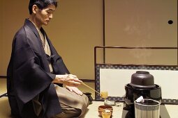 Tea master at tea ceremony, cleaning utensils