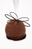 Eine Kugel Schokoladeneis & Schokoladenblume auf einem Löffel