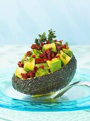 Stuffed avocado with dried tomatoes and pink pepper