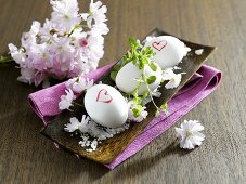 Three boiled eggs in a dish with salt and blossom