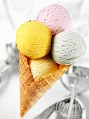 Scoops of four different ice creams in cone