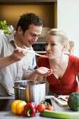 Young couple tasting tomato sauce