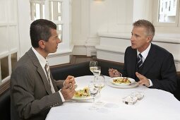 Two men having a discussion over lunch in a restaurant