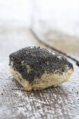 A poppy-seed roll on a wooden surface