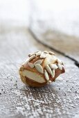 A lye bread roll with sunflower seeds on a wooden surface