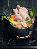 A soup chicken in a pot with vegetables