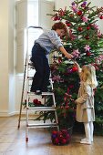 Two children decorating a Christmas tree