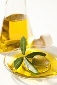 Ein Schälchen Olivenöl mit einer Olive