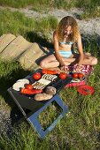 A young woman in a swimsuit having a barbeque