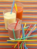 Three different fruit cocktails with coloured straws