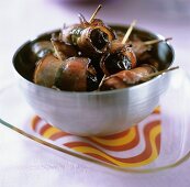 Bacon-wrapped prunes in a small bowl